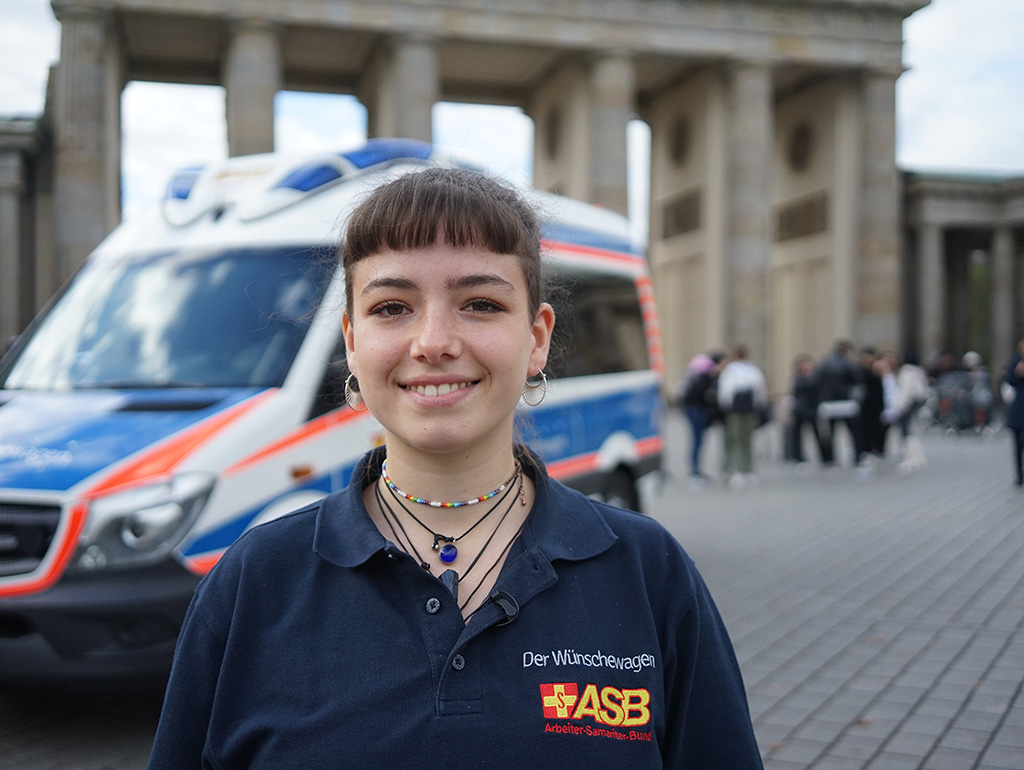 Wunscherfüllerin mit Wünschewagen vor dem Brandenburger Tor.