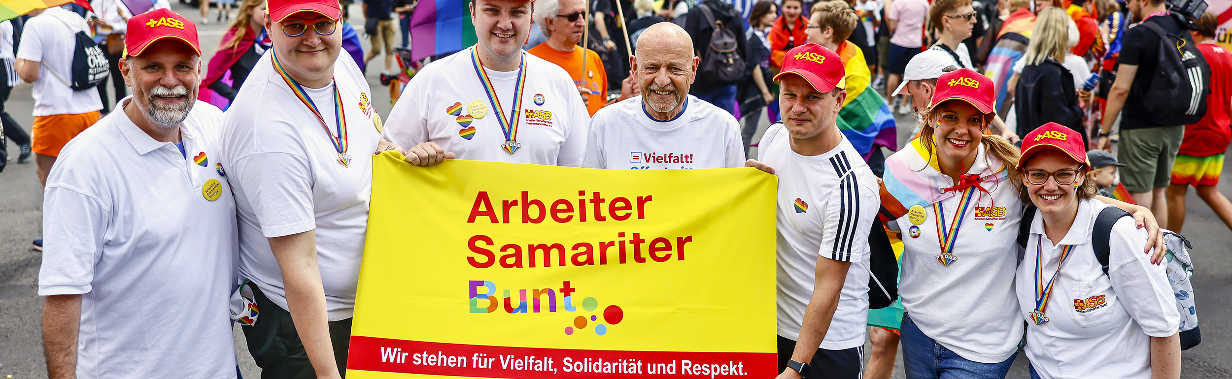 Samariter:innen beim CSD 2023 mit Arbeiter-Samariter-Bunt-Transparent für Vielfalt, Solidarität und Respekt.